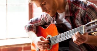 blonde man in shirt playing guitar