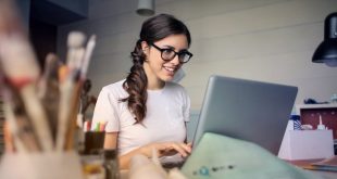 Woman smiling at her laptop because she now knows how to unblur a picture