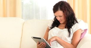 young woman sitting on the couch using her iPad
