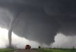 Truck in the distance driving perilously close to a tornado
